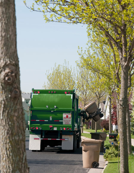Photo of Enviro-Tech truck picking up residential trash carts off the street.