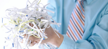 Photo of businessman throwing away shredded paper.