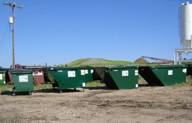 Photo of several commercial trash bins of varying sizes.