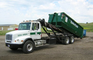 Photo of truck unloading roll-off container.